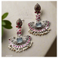 Ornate earrings with gemstones and pearls on a light background